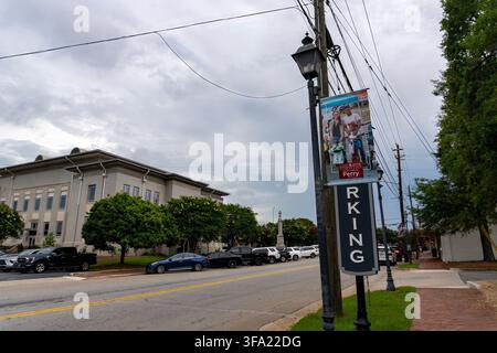 Reisen und Orte: Historische Szene in der Innenstadt von Perry Street mit Laternenpfahl-Banner und Parkplatzschild in Perry, Georgia Stockfoto