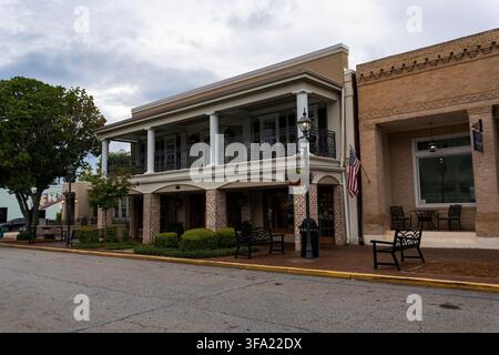 Reisen und Orte: Historisches zweistöckiges Gewerbegebäude im Stadtzentrum mit Balkon und amerikanischer Flagge in Perry, Georgia Stockfoto