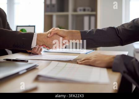 Geschäftliche Handschlag über Vertragspapieren im Büro nach erfolgreicher Vereinbarung Stockfoto