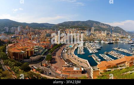 Luftpanorama von Monte Carlo, Monaco, mit luxuriöser Yachthafen, dichter Skyline von Wohnhochhäusern und Bergen, die sich hinter der Küstenlinie erheben Stockfoto
