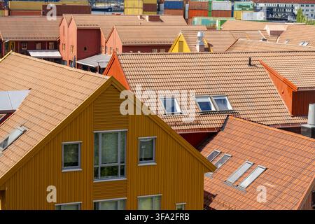 Blick auf farbenfrohe Holzhäuser mit Dachziegeln aus Terrakotta und Dachfenstern im historischen Viertel von Kristiansand, Agder, Norwegen. Stockfoto