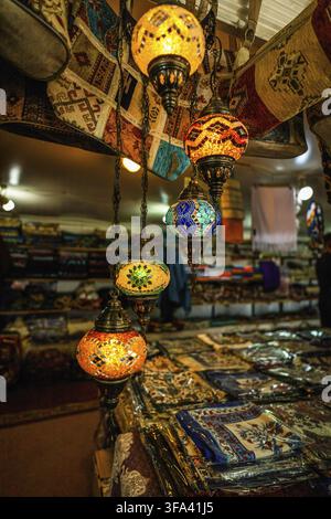 Kappadokien, Türkei - 14. September 2021: Pulsierende türkische Lampen hängen über bunten Textilien auf einem Marktplatz und zeigen ein reiches kulturelles Erbe und AR Stockfoto