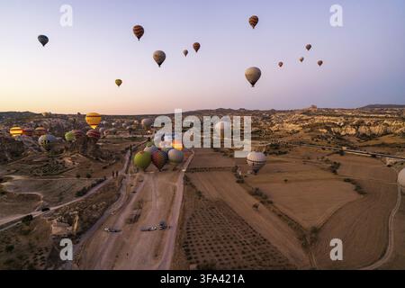Kappadokien, Türkei - 14. September 2021: Weitwinkelaufnahme von bunten Heißluftballons, die am frühen Morgen in Goreme am Himmel schweben Stockfoto