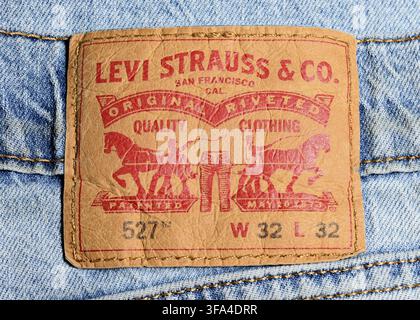Levi's 527 Jeans Etikett Leder-Patch Nahaufnahme zeigt ikonische Markenelemente und Modellnummer geprägt auf dem klassischen Rückenbundetikett Stockfoto