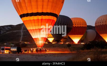 Heißluftballone, die sich für den Sonnenaufflug in Göreme, Kappadokien, Türkei vorbereiten Stockfoto