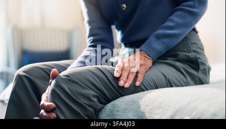 Seniorin, Frau und Hände im Schlafzimmer mit Knieschmerzen, Arthritis-Symptomen oder schwachen Beinmuskeln durch Verletzung. Verletzte, ältere Person und Gelenkentzündung in Stockfoto