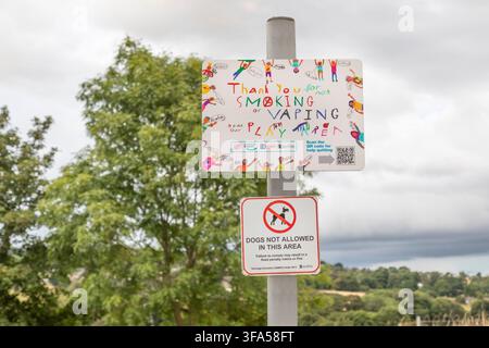 Schilder "Rauchen und Vaping verboten" und "Hunde nicht erlaubt" auf einem Kinderspielplatz in Oakworth, Yorkshire. Stockfoto