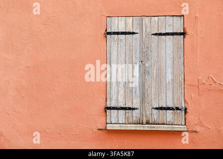 Vintage-Holzfenster an einer verwitterten Putzwand eines historischen Hauses Stockfoto