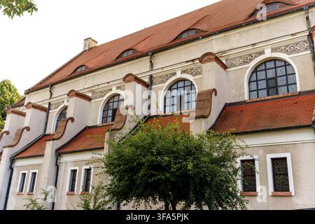 Eine Außenansicht eines historischen Steinbaus mit Terrazzoflieschendach und charakteristischen gewölbten Fenstern, das traditionelle europäische Architektur darstellt Stockfoto