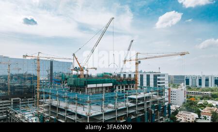 Großes kommerzielles Hochhaus im Bau mit mehreren Turmkranen Stockfoto