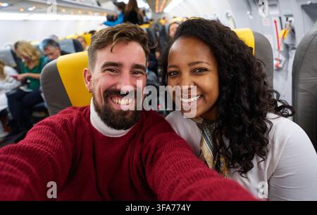 Paar macht ein Selfie in einem Flugzeug während des Fluges. Stockfoto