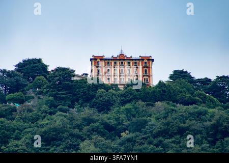 Schöne historische Villa auf einem grünen Hügel, umgeben von üppigem Wald am Comer See, Lombardei, Italien. Stockfoto