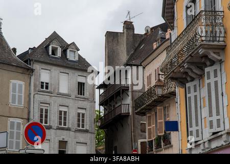 Eine architektonische Straßenansicht von historischen europäischen Stadthäusern mit mehrstufigen Holzbalustraden, schmiedeeisernen Geländern, weißen Lamellenfensterläden Stockfoto