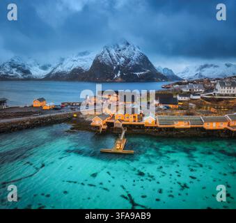 Blick aus der Vogelperspektive auf das Fischerdorf Hamnoy mit gelbem rorbuer Stockfoto