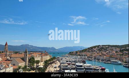 Erhöhte weite Panoramaaussicht auf die Bucht und den Hafen von Trogir in Kroatien mit türkisfarbenem Wasser, Yachthäfen, Werftkränen und Küstenhügeln Stockfoto