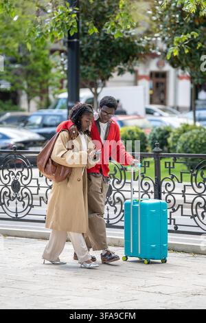 Lächelnde afroamerikaner verheiratete Paare, Männer und Frauen, die auf der Straße in der neuen Stadt spazieren gehen. Stockfoto