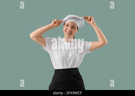 Karriereambitionen in der Küche und berufliche Entwicklung, junge Chefköchin in Uniform, die mit einem hoffnungsvollen Ausdruck nach oben schaut Stockfoto