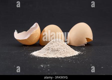 Eierschalenpulver mit zerbrochenen Eierschalenstücken auf der Oberfläche Stockfoto
