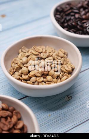 Kaffeebohnen in Schüsseln auf einem blauen Holztisch Stockfoto