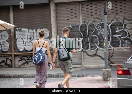 BANGKOK, THAILAND - 12. AUGUST 2026: Touristenpaar geht im Bereich der Song-Wat-Straße, Rückansicht. Stockfoto