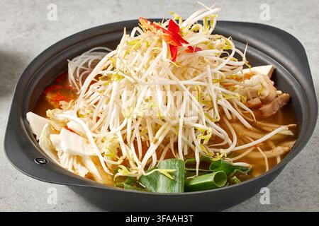 Traditionelles koreanisches Vollmenü mit Doenjang Jjigae Sojabohnenpaste-Eintopf, Reis und verschiedenen Banchan-Beilagen in goldenen Schüsseln auf einem Holztablett, Kor Stockfoto