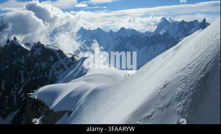Bergsteiger auf einem schneebedeckten Grat, gesehen vom Aussichtsdeck der Aiguille du Midi Stockfoto