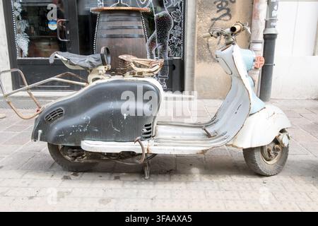 Vintage rostiger Retro-Scooter, der auf einer Kopfsteinpflasterstraße in Krakau geparkt ist Stockfoto