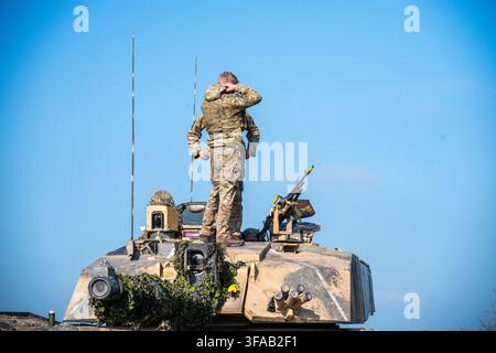 Ansicht eines Soldaten in Tarnuniform, der auf einem britischen Armeeschützpanzer auf der Salisbury Plain steht, Salisbury, Wiltshire, Vereinigtes Königreich. Stockfoto