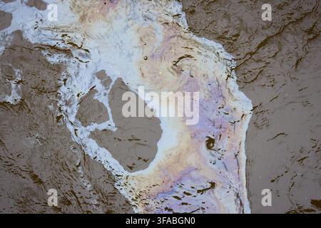 Eine abstrakte Wasserreflexion mit irisierender Farbe und welliger Textur, die ein flüssiges Naturmuster erzeugt Stockfoto