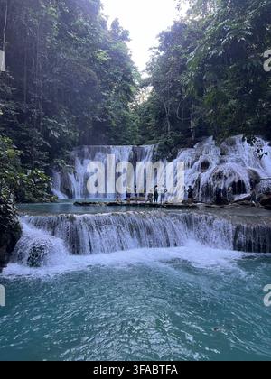Mehrstufiger tropischer Wasserfall, der in türkisfarbene Pools stürzt, umgeben von dichtem Regenwald in Sulawesi, Indonesien. Stockfoto