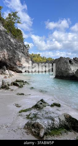 Abgeschiedene felsige Bucht mit klarem türkisfarbenem Wasser und schroffen Kalksteinformationen an einer tropischen Küste in Sulawesi, Indonesien. Stockfoto