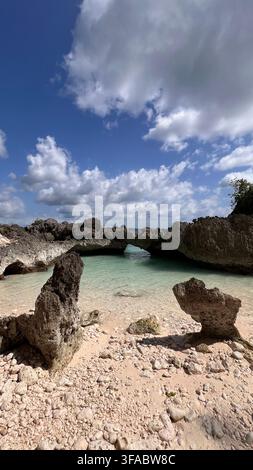 Natürlicher Kalksteinbogen und türkisfarbener Felsenpool an einer abgelegenen tropischen Küste in Sulawesi, Indonesien. Stockfoto