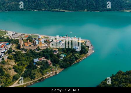 Luftbild des Ananuri-Festungskomplexes am Ufer des türkisfarbenen Zhinvali-Stausees, umgeben von üppigen grünen Hügeln und Bäumen, Ananuri, Mtskheta- Stockfoto