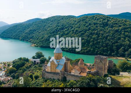 Luftaufnahme des historischen Ananuri-Festungskomplexes am Ufer des türkisfarbenen Zhinvali-Stausees, umgeben von üppigen grünen Bergen in Ananuri Stockfoto