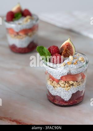 Eleganter Frühstücks-Parfait, der Chiapudding, frische Früchte und knusprige Granola kombiniert Stockfoto