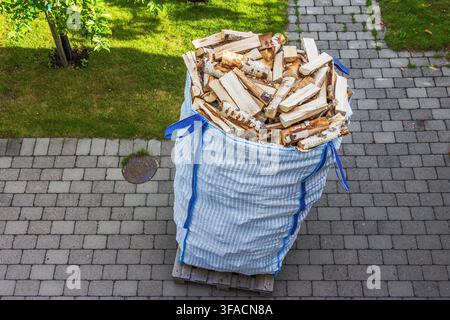 Oberansicht eines gekauften Sackes mit gespaltenem Birkenholz für die Winterlagerung im Hof der Sommervilla. Schweden. Stockfoto