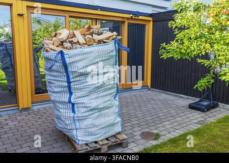 Nahaufnahme von geliefertem Brennholz in Bigbag auf Holzpalette vor der Villa. Schweden. Stockfoto