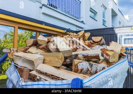 Nahaufnahme von geliefertem gehacktem Feuerholz in einem großen Sack vor einer modernen Villa. Schweden. Stockfoto