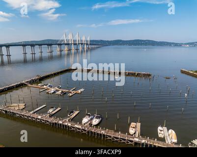 Luftaufnahme der Governor Mario M. Cuomo Bridge, die den Hudson überquert, mit einem Yachthafen mit Holzstegen und festgemachten Booten in Tarrytown, New Yo Stockfoto