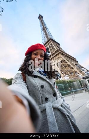 Frau, die vor dem Eiffelturm in Paris ein Selfie macht Stockfoto