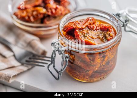 Sonnengetrocknete Tomaten in einem Glas verpackt und in Olivenöl mit Kräutern konserviert. Warme, rustikale Lebensmittelstyling erinnert an hausgemachte, mediterrane Aromen perfe Stockfoto