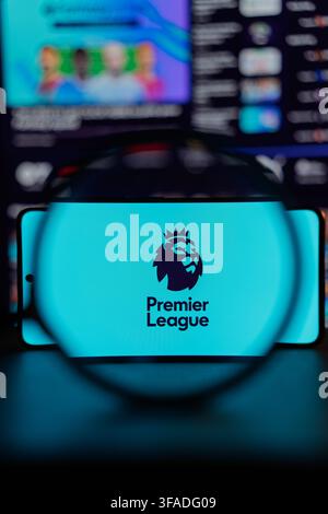 Premier-League-Logo auf einem Smartphone-Bildschirm unter einer Lupe vor dunklem verschwommenem Hintergrund dargestellt, Konzept für englischen Fußball und Sportmedien. Stockfoto