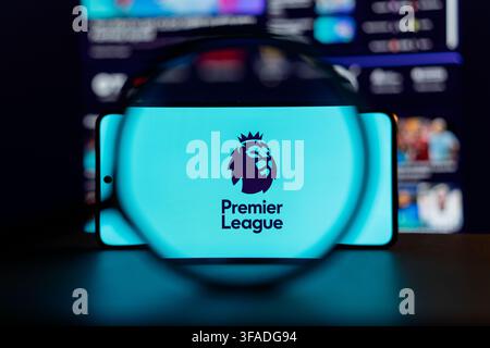 Premier-League-Logo auf einem Smartphone-Bildschirm unter einer Lupe vor dunklem verschwommenem Hintergrund dargestellt, Konzept für englischen Fußball und Sportmedien. Stockfoto