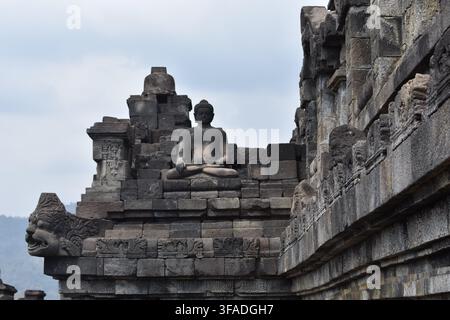 Eine einsame Steinstatue des Buddha sitzt in Meditation am Rand der Borobudur-Tempelstufen. Bali, Indonesien. Stockfoto