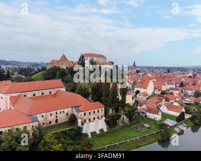 Luftaufnahme von Ptuj, Slowenien, mit dem Stadtzentrum, rot gedeckten Gebäuden und der Drau sowie der Burg Ptuj. Stockfoto