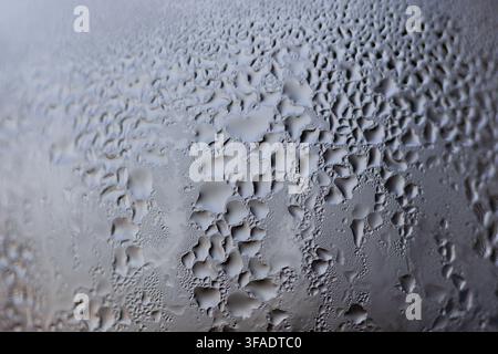 Nahaufnahme von Wasserkondensation, die deutliche Tröpfchen und Feuchtigkeitsansammlungen auf einem Weinglas bildet. Stockfoto