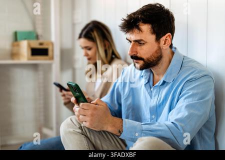 Gadget-sucht und Beziehungsprobleme. Ein Paar mit Smartphones, die sich gegenseitig ignorieren Stockfoto