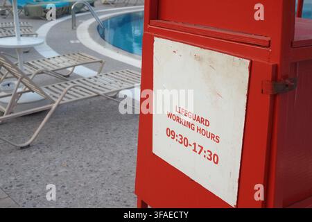 Schild mit den Arbeitszeiten des Rettungsschwimmers in der Nähe des Pools Stockfoto