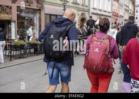 Krakau, Polen, 23.08.2025: Ein Mann und eine Frau gehen zusammen in Krakau, Polen. Der Mann ist mittleren Alters mit kurzen blonden Haaren, trägt eine dunkle Jacke und Stockfoto