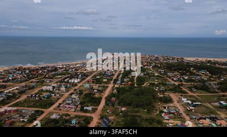 Luftaufnahme der Strandgemeinde Punta del Diablo mit farbenfrohen Häusern und sandigen Ufern. Die Szene zeigt den Grundriss der Stadt vor dem Meer ho Stockfoto